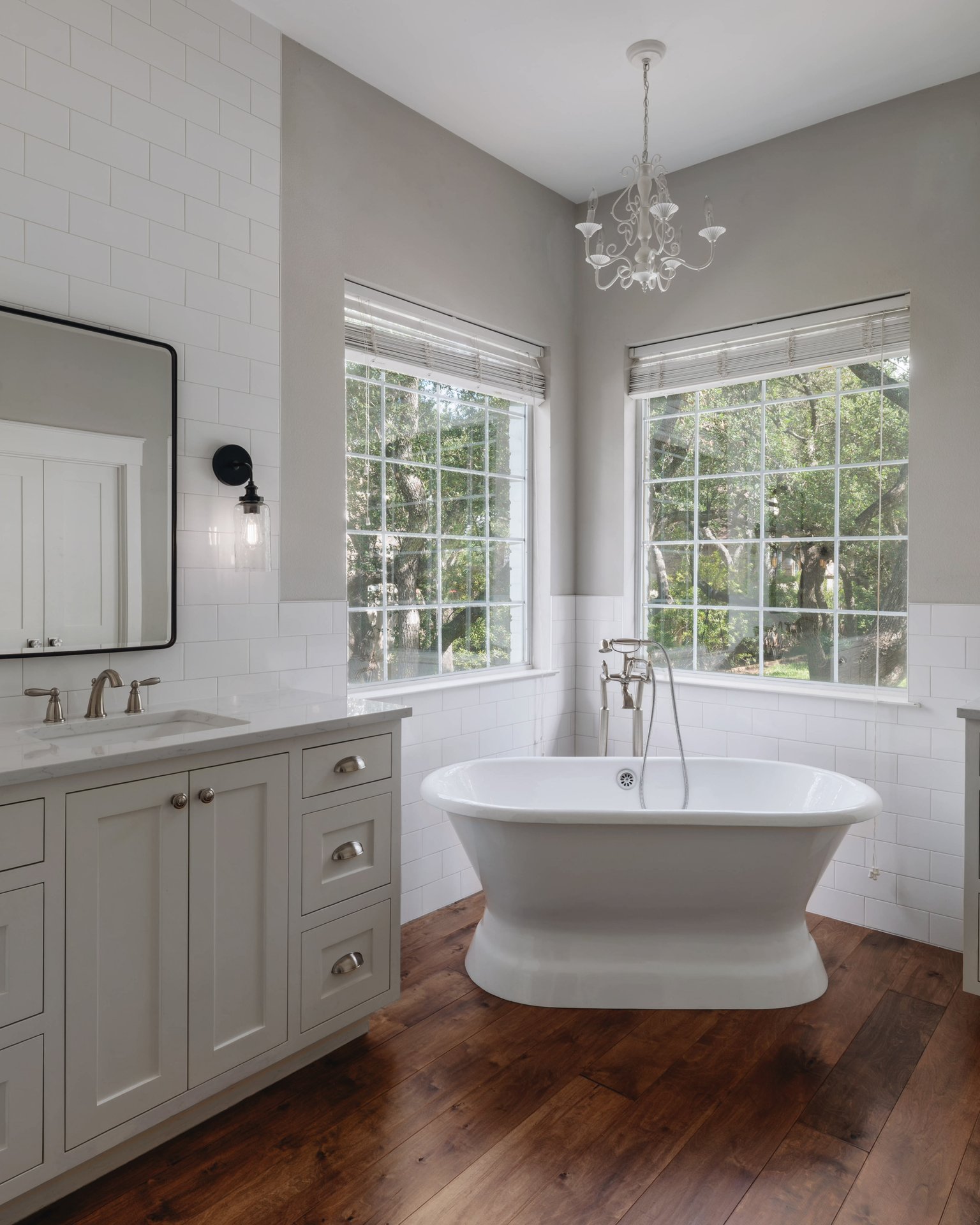 5512 Ballenton Lane Austin, TX 78739 - Photo 22 of 40 Indulge in relaxation within this primary bathroom featuring a freestanding tub and warm hardwood flooring.