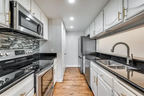 a kitchen with stainless steel appliances granite countertop a sink stove and refrigerator
