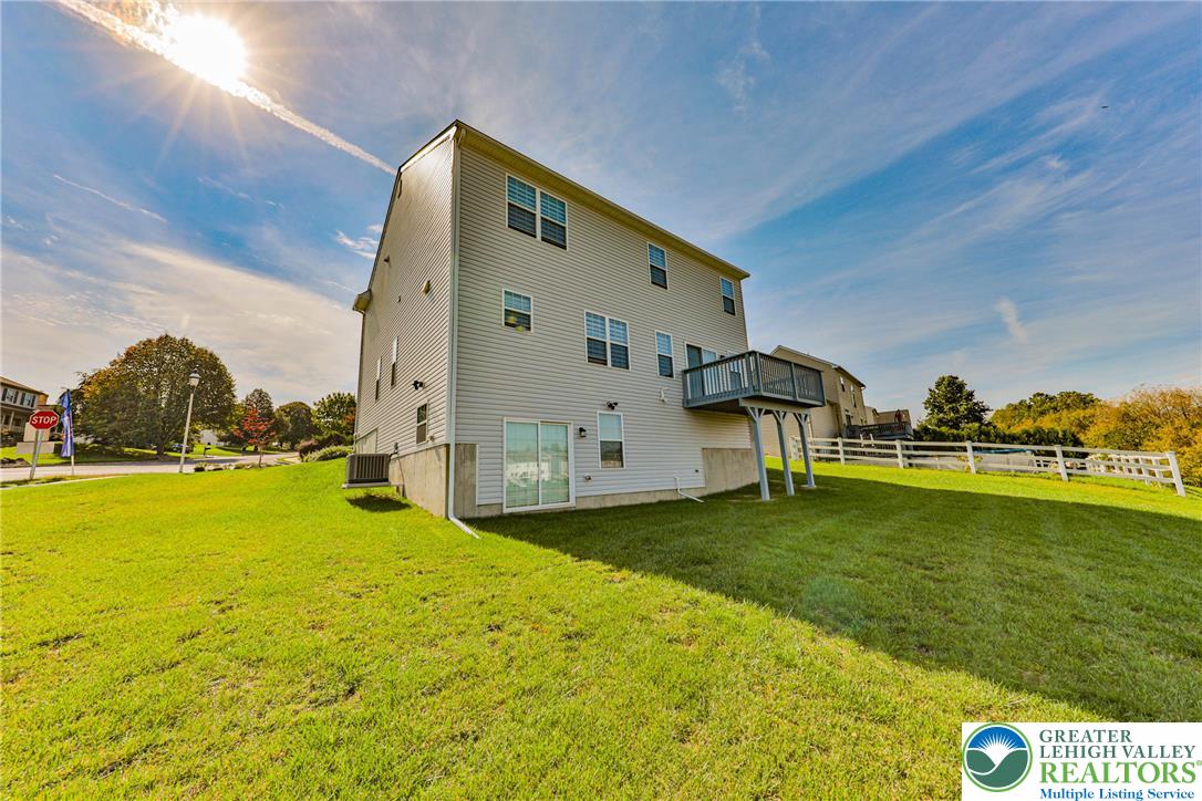 1105 Meco Road Easton, PA 18040 - Photo 92 of 100 A spacious green lawn borders this multi-level home featuring a private elevated deck and walk-out basement.