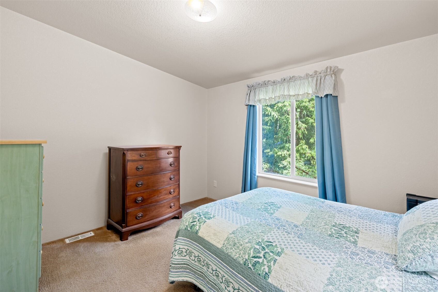 423 Fleming Drive Sequim, WA 98382 - Photo 19 of 33 a bedroom with a bed and a dresser