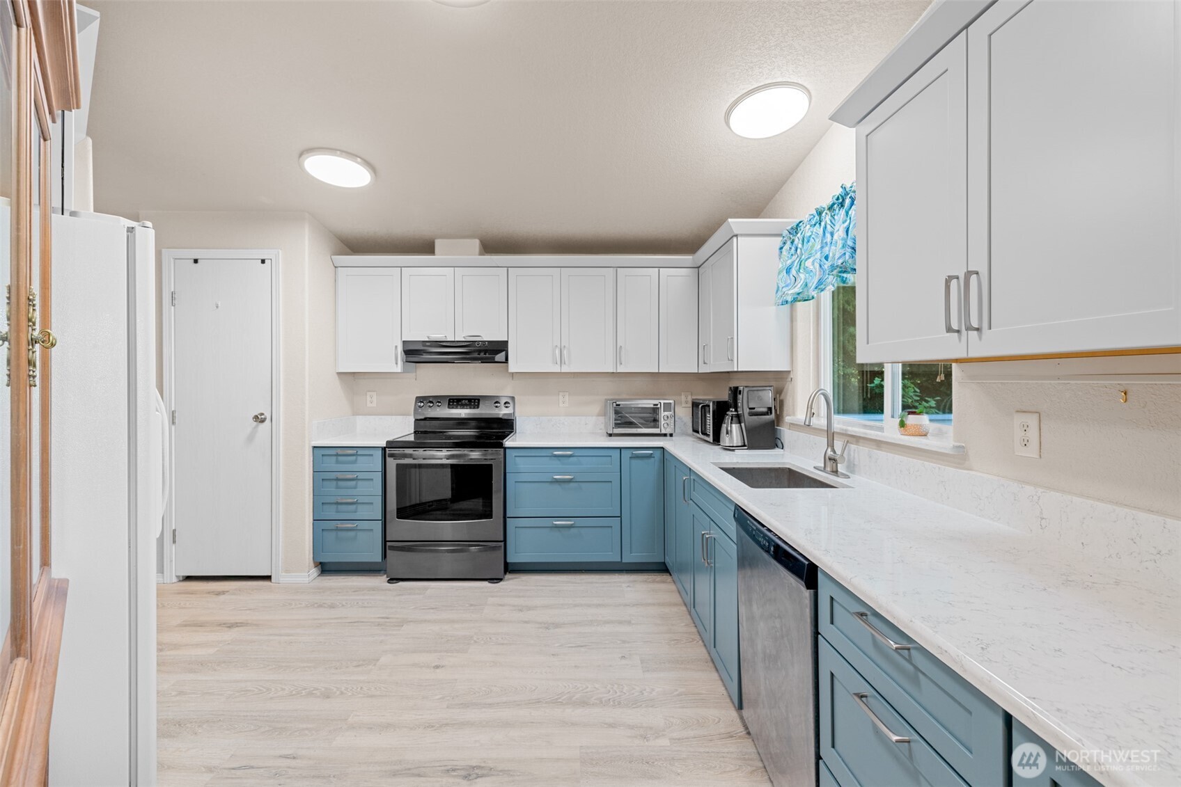 423 Fleming Drive Sequim, WA 98382 - Photo 7 of 33 a kitchen with granite countertop a refrigerator and a stove top oven