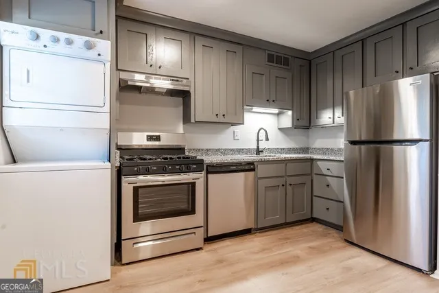 a kitchen with cabinets stainless steel appliances and wooden floor