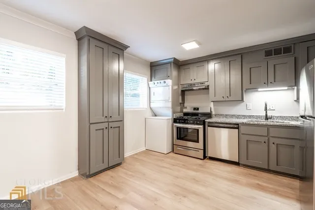 a kitchen with granite countertop a refrigerator stove top oven and sink