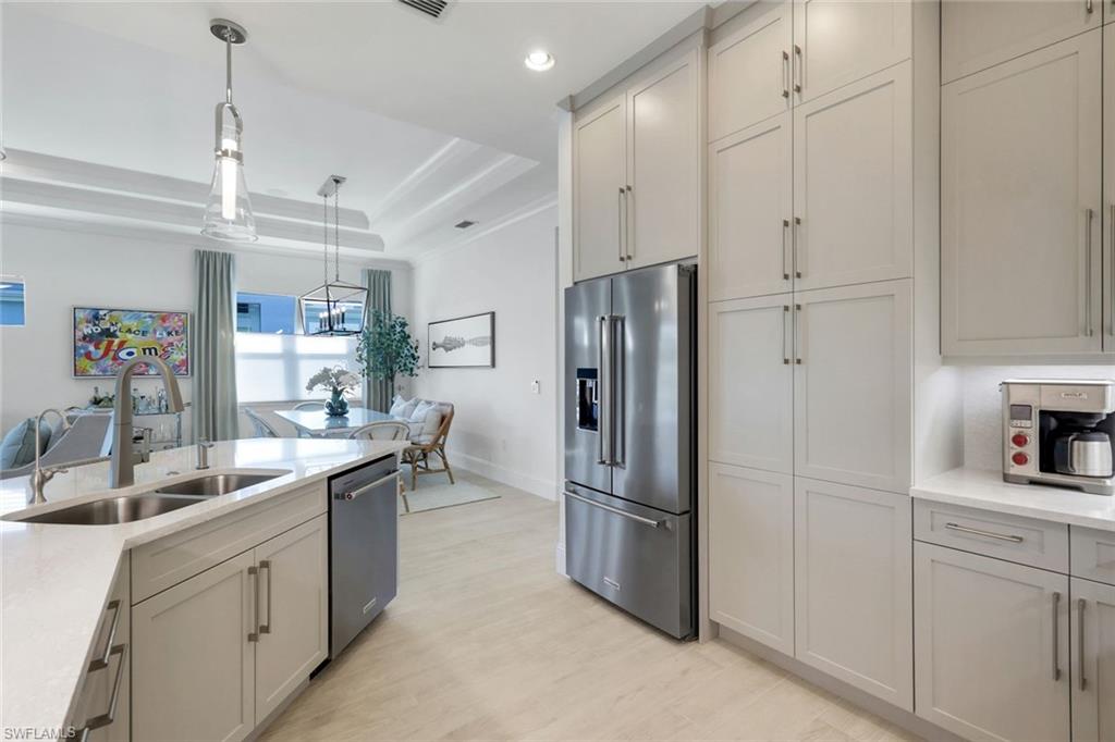 8825 Yucatan Court Naples, FL 34113 - Photo 12 of 45 a kitchen with refrigerator and cabinets