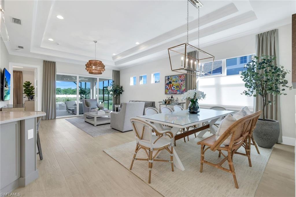 8825 Yucatan Court Naples, FL 34113 - Photo 14 of 45 a view of a dining room and livingroom with furniture wooden floor a chandelier