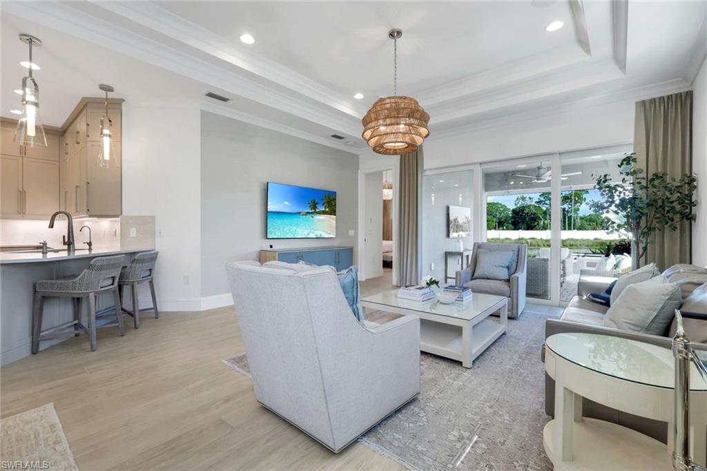 8825 Yucatan Court Naples, FL 34113 - Photo 15 of 45 a living room with furniture a chandelier and a flat screen tv