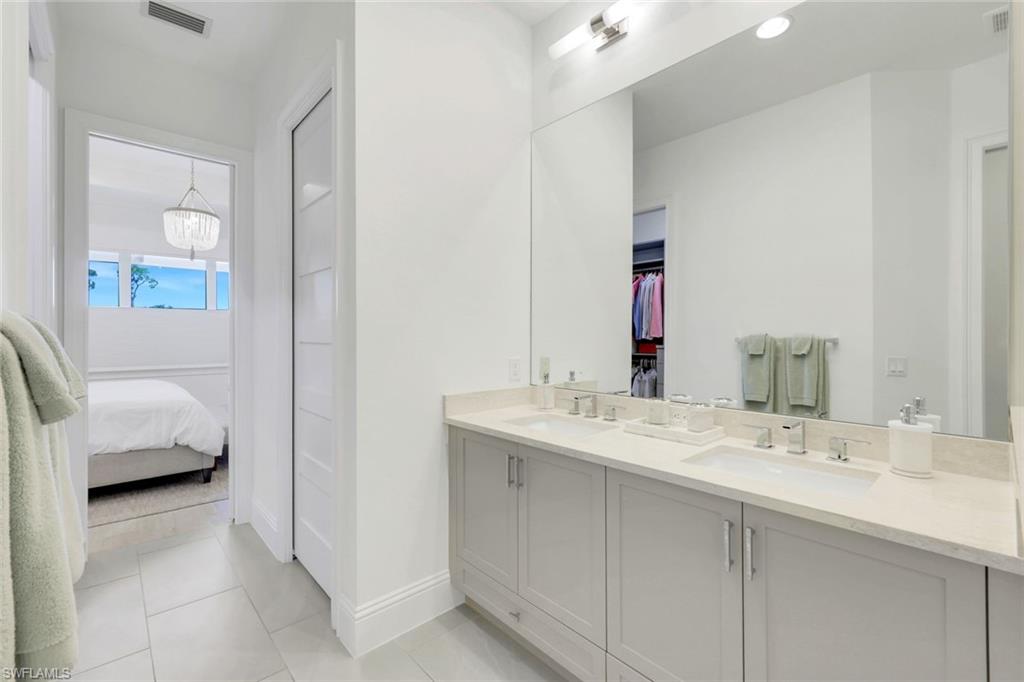 8825 Yucatan Court Naples, FL 34113 - Photo 19 of 45 a en suite bathroom with a sink and a mirror