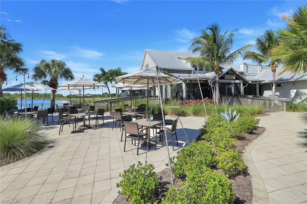 8825 Yucatan Court Naples, FL 34113 - Photo 42 of 45 a view of a chairs and table in patio with a table and chairs under an umbrella in patio