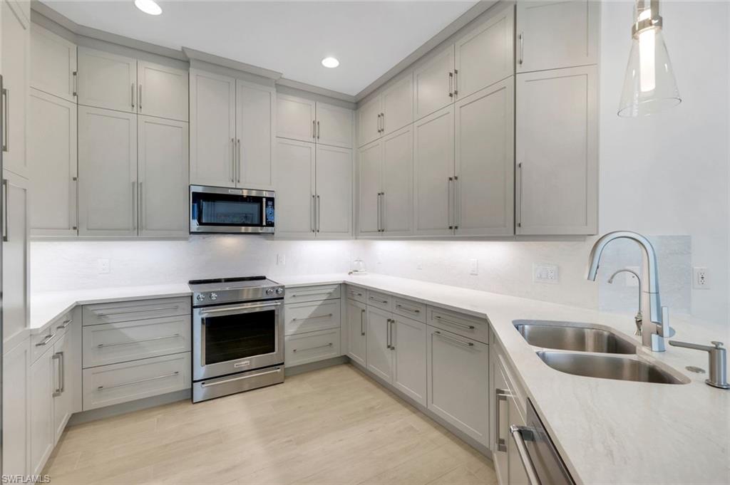 8825 Yucatan Court Naples, FL 34113 - Photo 10 of 45 a kitchen with stainless steel appliances granite countertop a sink dishwasher a stove and a refrigerator with wooden cabinets