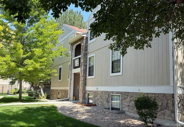 a front view of a house with a yard and tree s