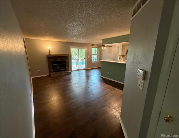 a view of an empty room with a fireplace and a window