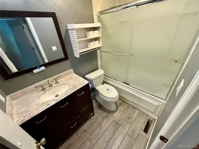 a bathroom with a granite countertop sink toilet and shower