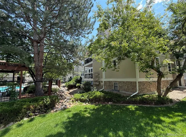 a view of backyard with table and chairs and a large tree