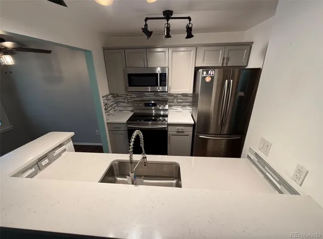 a kitchen with stainless steel appliances kitchen island a refrigerator sink and stove