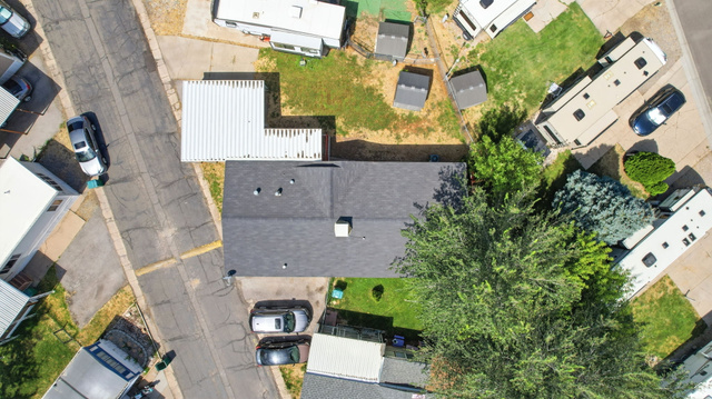 29 Grover Street Layton, UT 84041 - Photo 26 of 29 Aerial perspective showcasing a property with a dark shingle roof, established perimeter trees, and a paved street frontage
