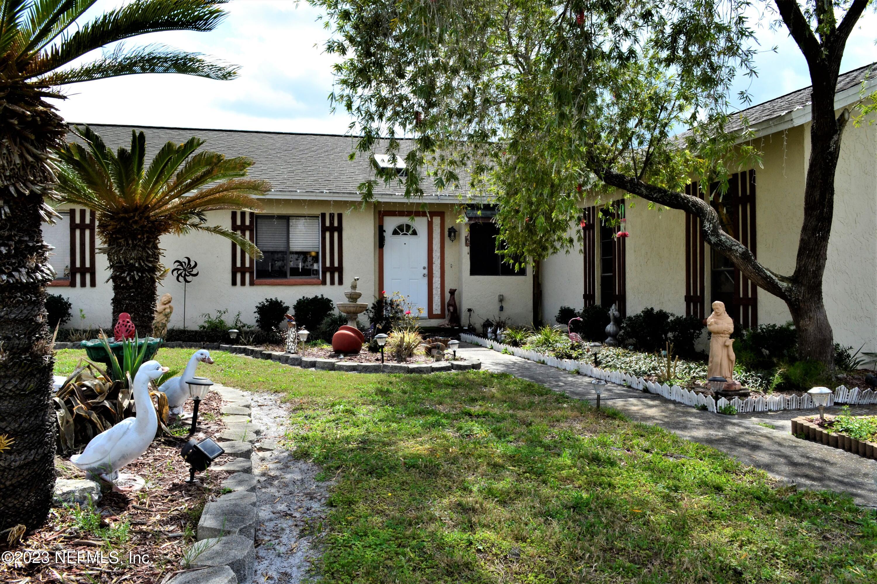 a view of a house with backyard and sitting area