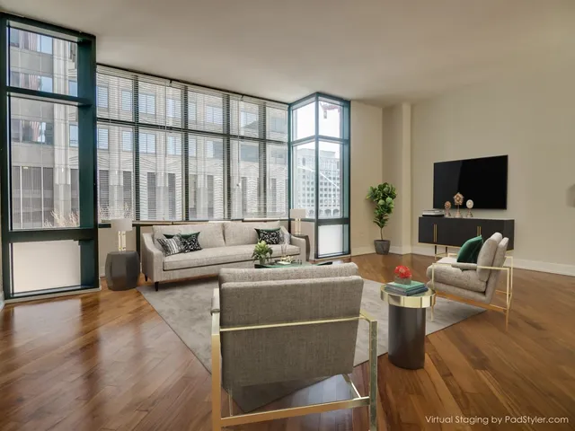a living room with furniture a flat screen tv and a floor to ceiling window