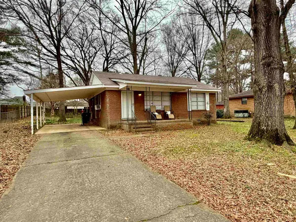 a view of a house with a yard patio and tree