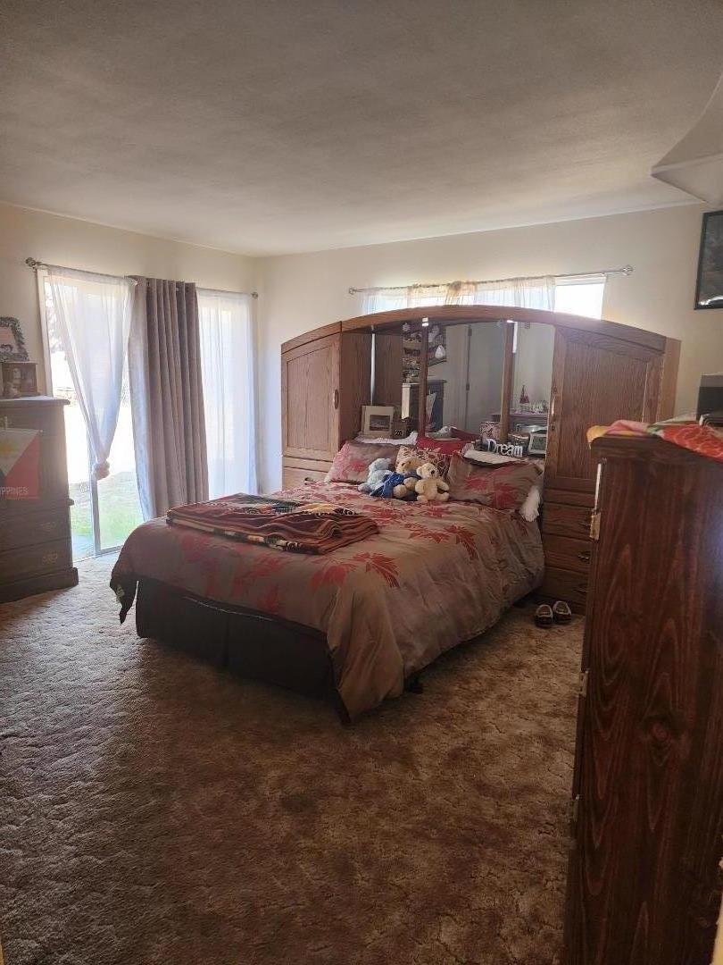 70 Overpass Road Watsonville, CA 95076 - Photo 21 of 29 a spacious bedroom with a bed and wooden floor