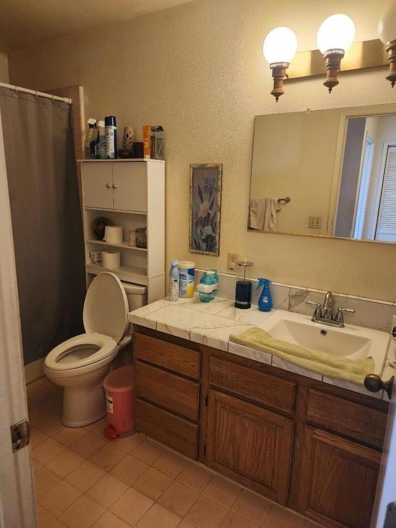 70 Overpass Road Watsonville, CA 95076 - Photo 25 of 29 a bathroom with a granite countertop toilet sink and mirror
