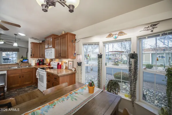 a living room with stainless steel appliances furniture a rug and a view of kitchen