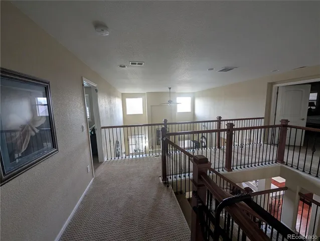 a view of a hallway with wooden floor stairs