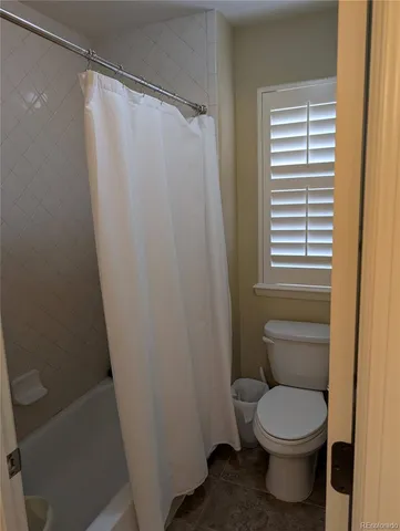 a white toilet sitting next to a shower curtain