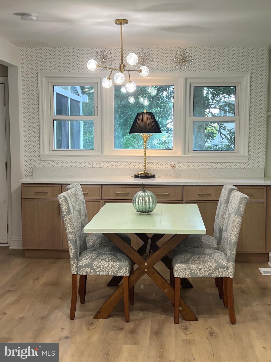 8802 2nd Avenue Silver Spring, MD 20910 - Photo 11 of 68 a dining room with wooden floor a chandelier a wooden table and chairs