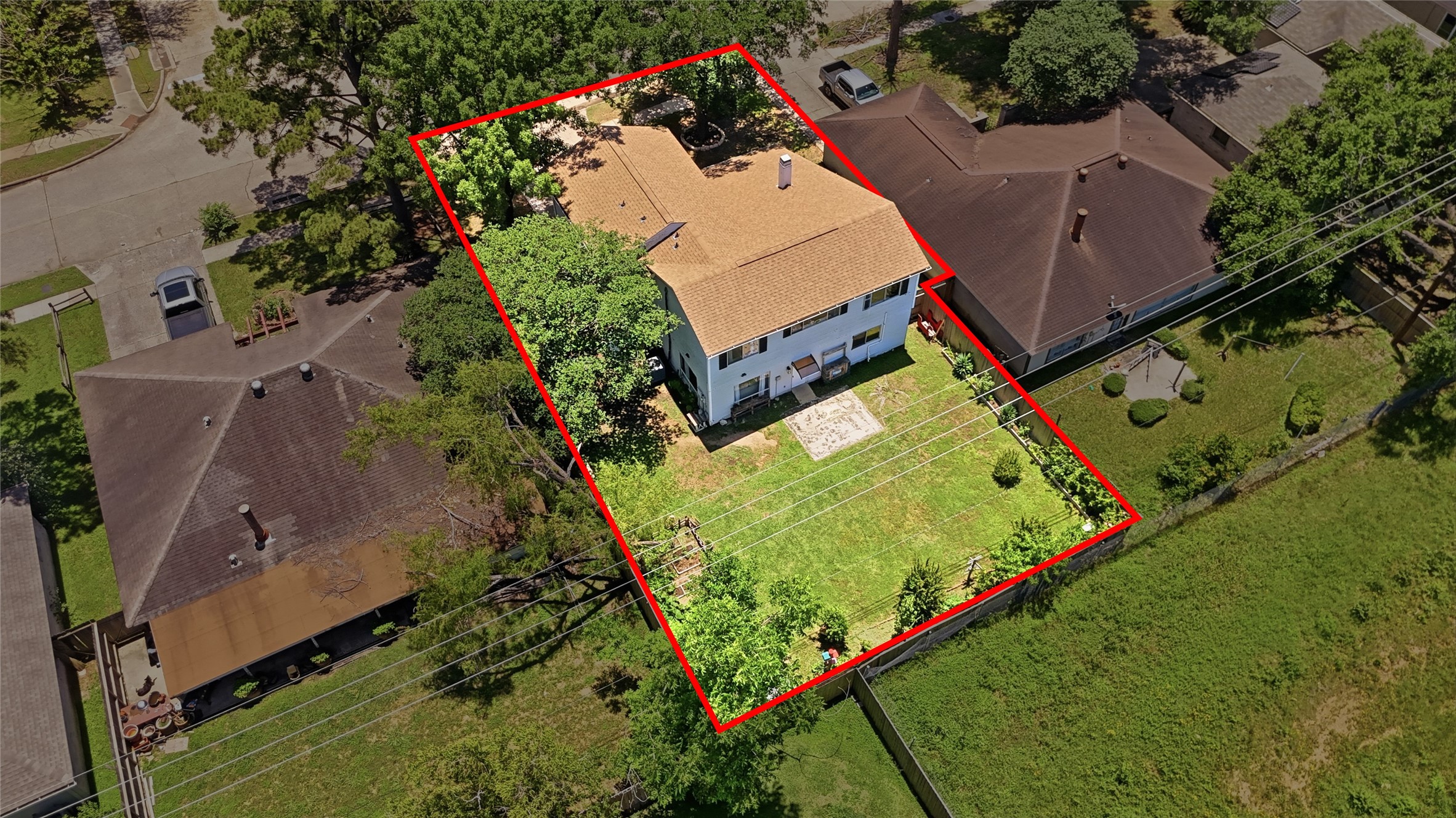 4718 Temple Bell Drive Spring, TX 77388 - Photo 46 of 50 Spacious two-story home with a large backyard, outlined in red, nestled between two neighboring houses. The property is surrounded by trees and offers a private, fenced yard with ample green space. Ideal for families seeking a serene neighborhood.