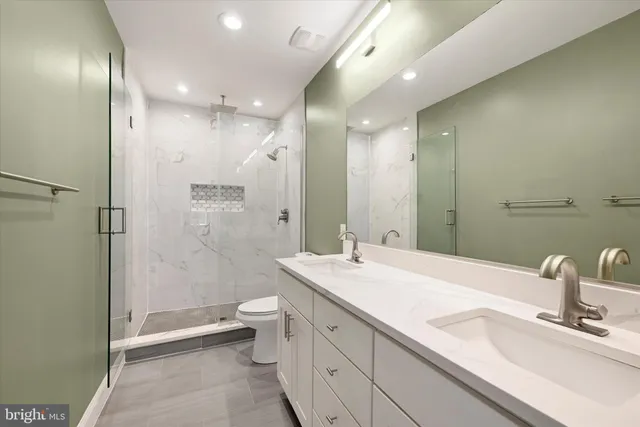 a bathroom with a double vanity sink toilet and shower