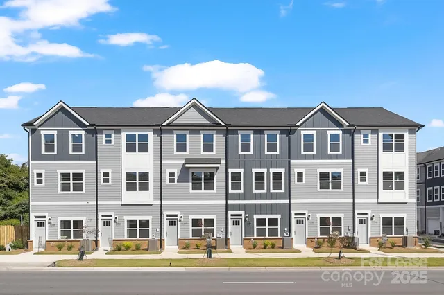 a front view of a residential apartment building with a yard