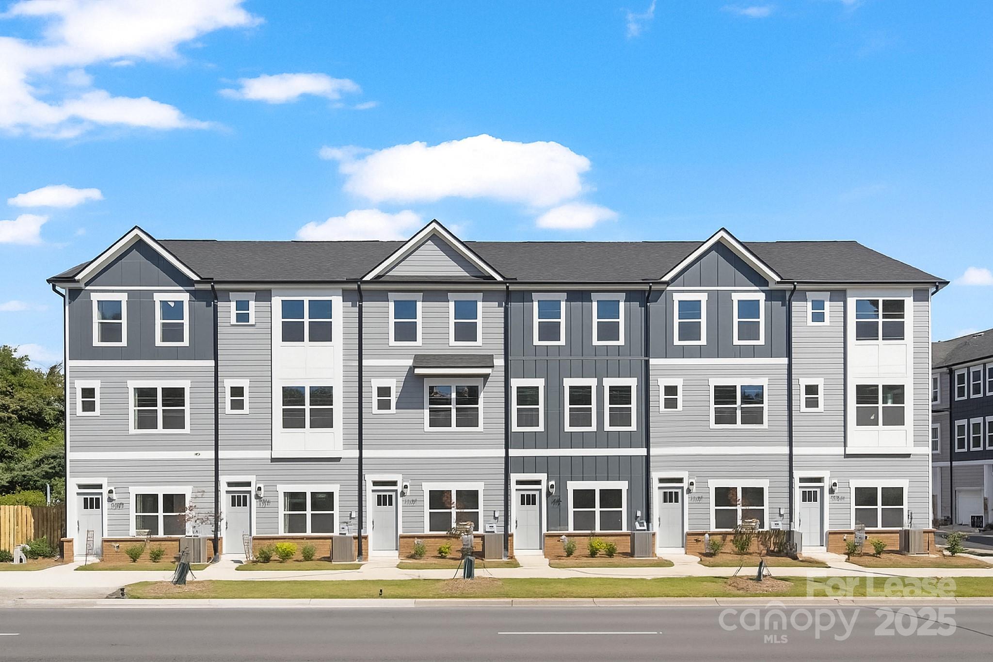 a front view of a residential apartment building with a yard