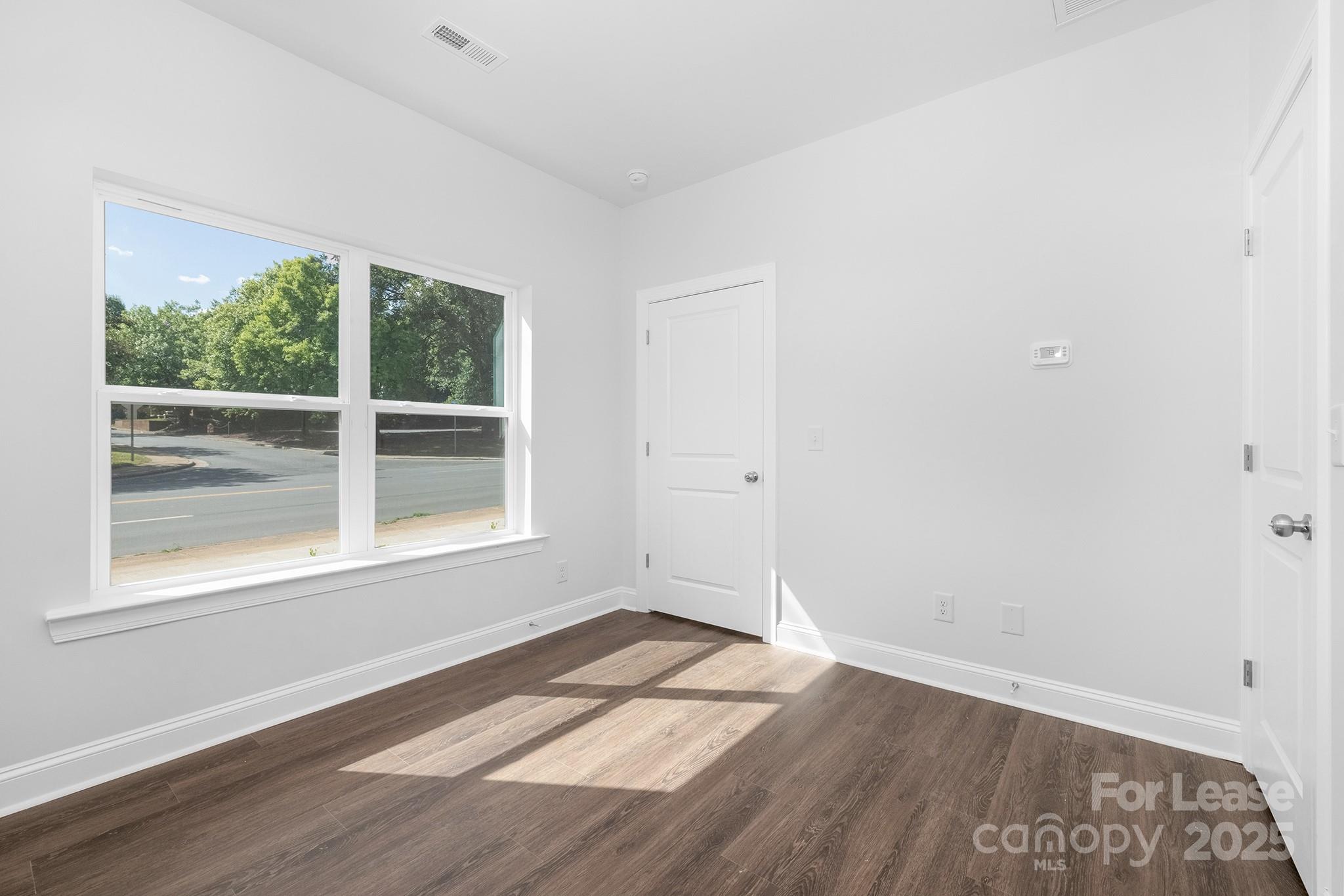 550 Beatties Ford Road Charlotte, NC 28216 - Photo 19 of 23 an empty room with wooden floor and windows