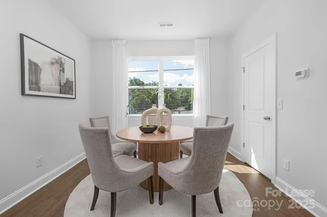 a dining room with furniture a rug and wooden floor