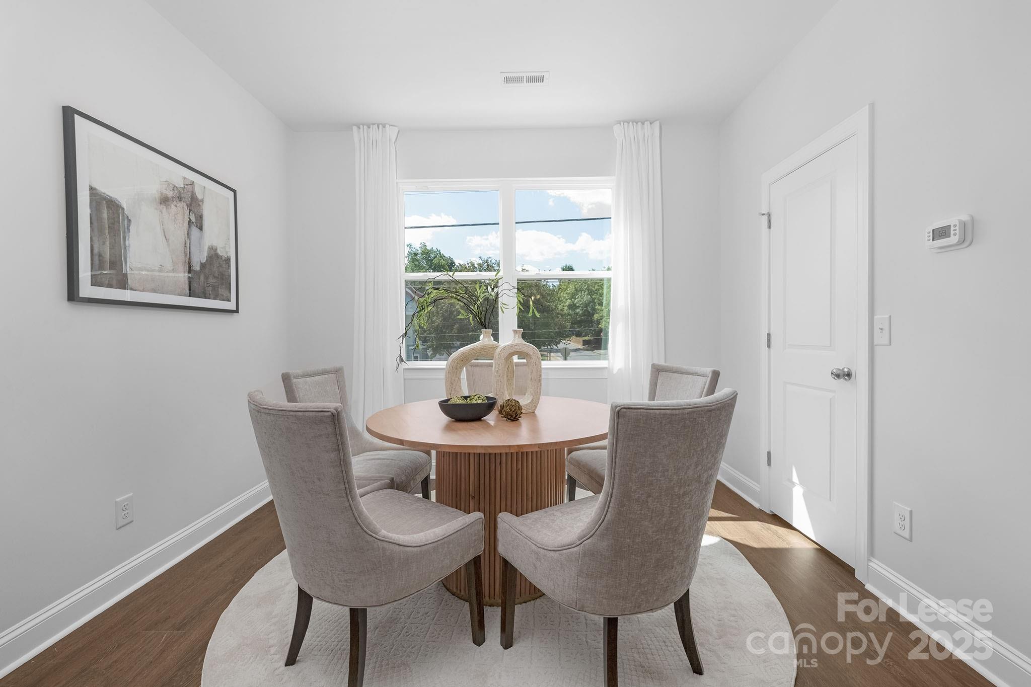 550 Beatties Ford Road Charlotte, NC 28216 - Photo 7 of 23 a dining room with furniture a rug and wooden floor