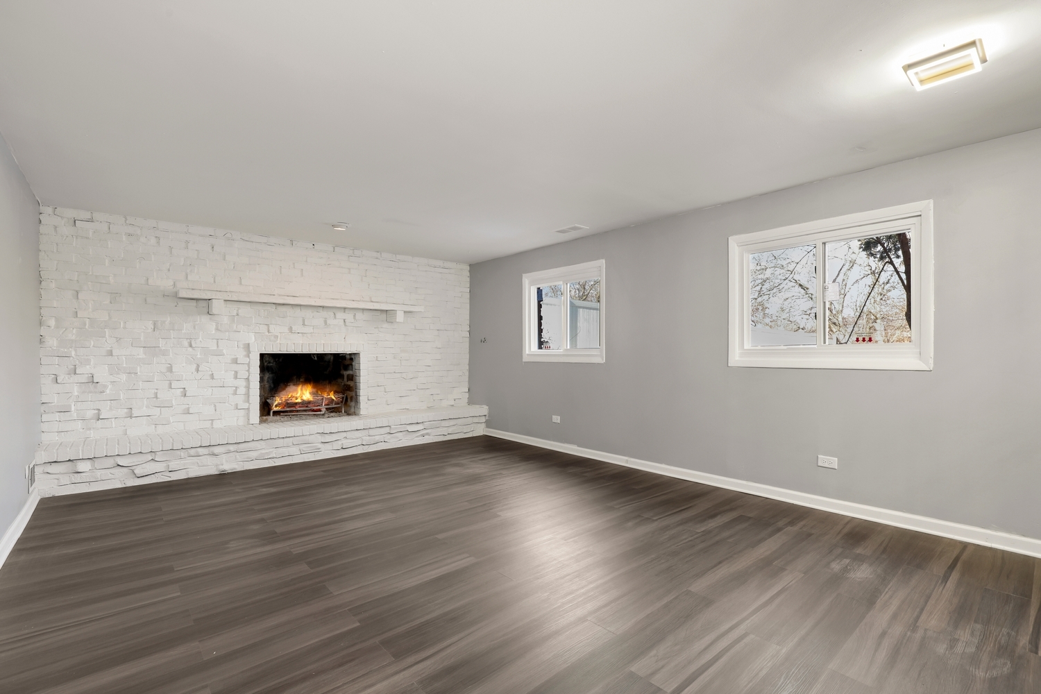 3518 South Manor Drive Lansing, IL 60438 - Photo 19 of 27 an empty room with wooden floor a fireplace and windows