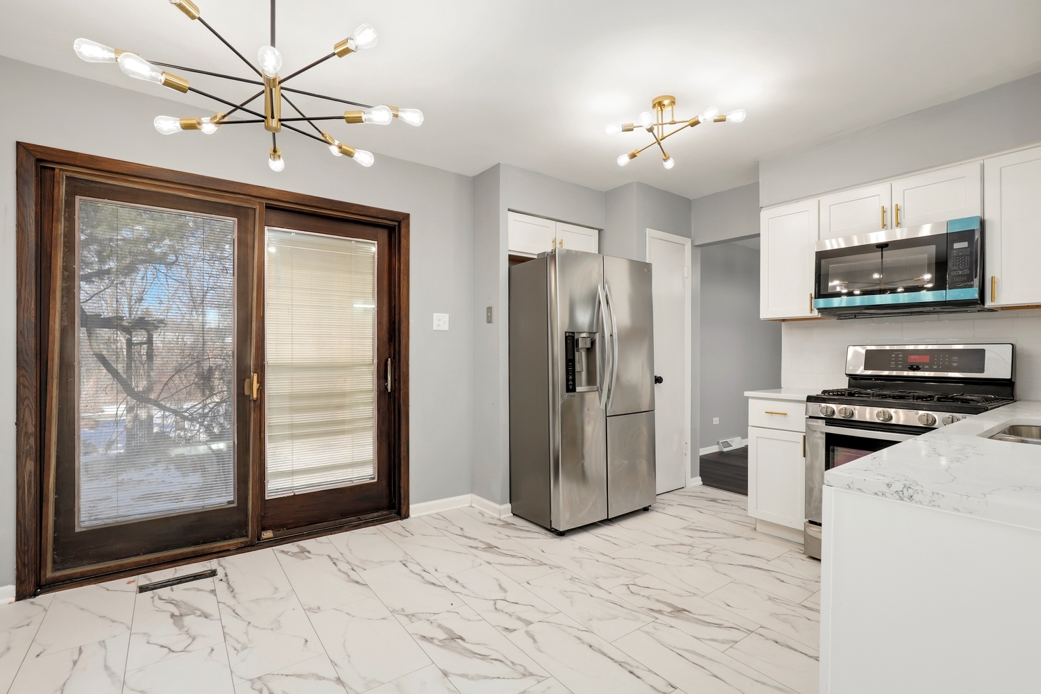3518 South Manor Drive Lansing, IL 60438 - Photo 9 of 27 a kitchen with stainless steel appliances granite countertop a stove refrigerator and microwave