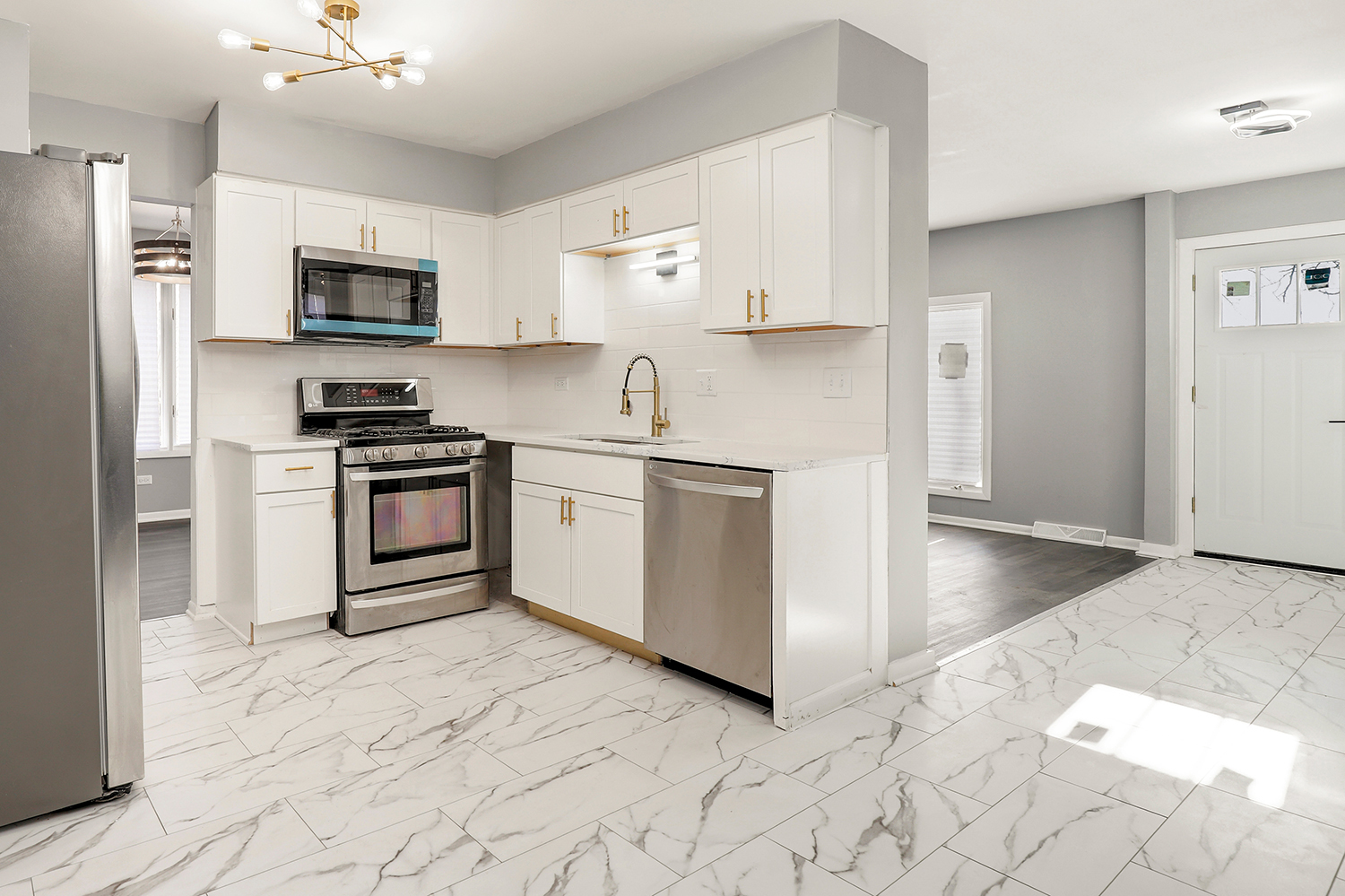 3518 South Manor Drive Lansing, IL 60438 - Photo 10 of 27 a kitchen with stainless steel appliances granite countertop a stove top oven a sink a refrigerator and white cabinets with wooden floor
