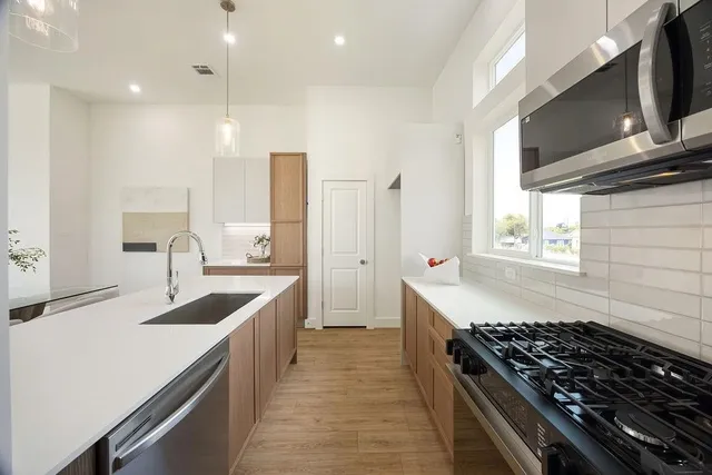 a kitchen with stainless steel appliances granite countertop a sink stove and refrigerator