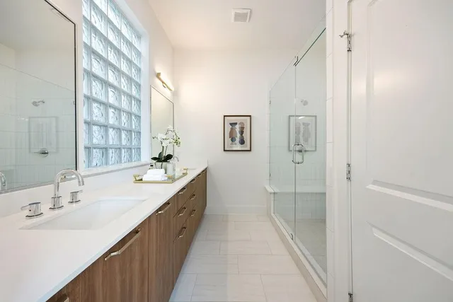 a spacious bathroom with a double vanity sink and mirror