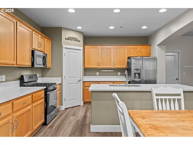 a kitchen with stainless steel appliances granite countertop a stove a sink dishwasher and a refrigerator