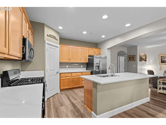 a kitchen with stainless steel appliances granite countertop a sink stove and refrigerator