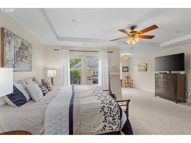 a bedroom with a bed a flat screen tv and a chandelier