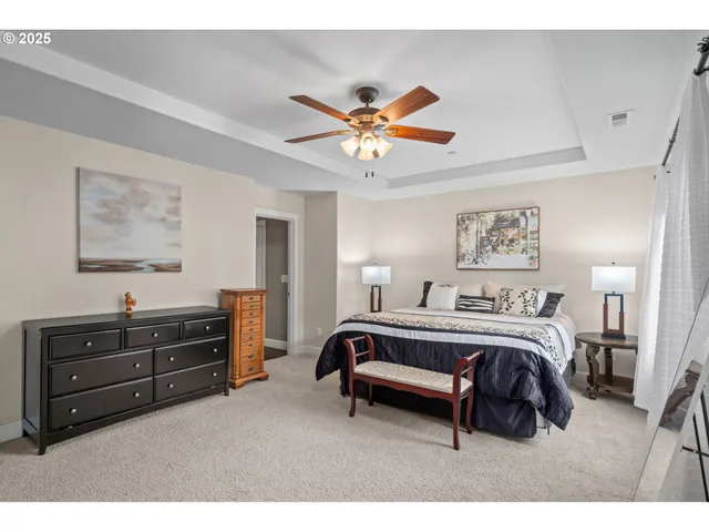 a spacious bedroom with a bed and a chandelier