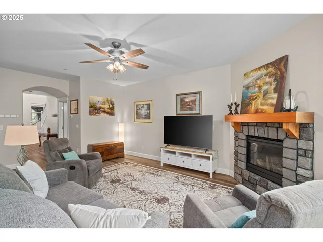 a living room with furniture a flat screen tv and a fireplace