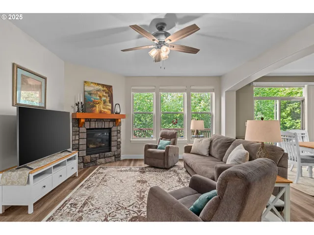 a living room with furniture a floor to ceiling window and a flat screen tv