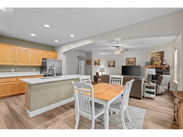 a kitchen with stainless steel appliances kitchen island granite countertop a dining table chairs and granite counter tops