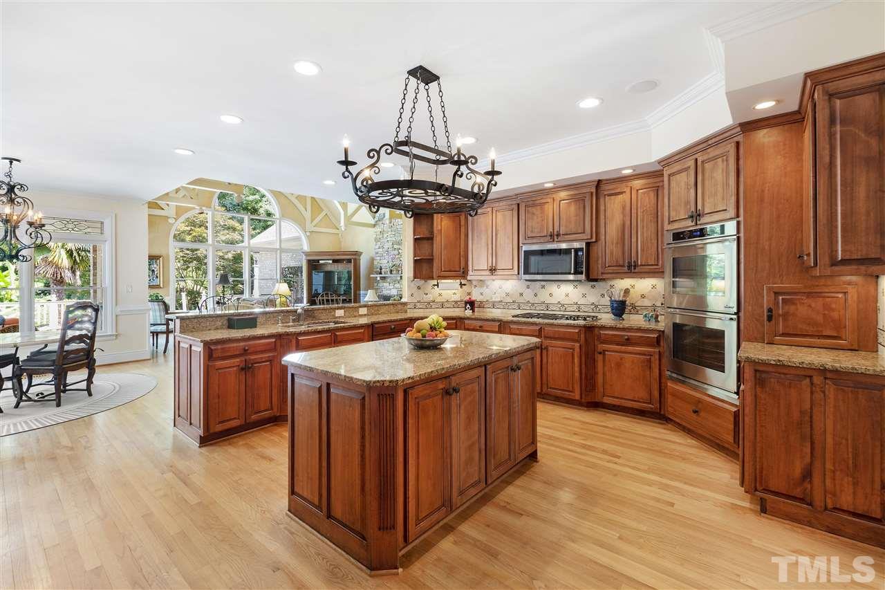 8423 Bournemouth Drive Raleigh, NC 27615 - Photo 6 of 30 a kitchen with stainless steel appliances granite countertop a stove a sink dishwasher and a refrigerator with wooden floor