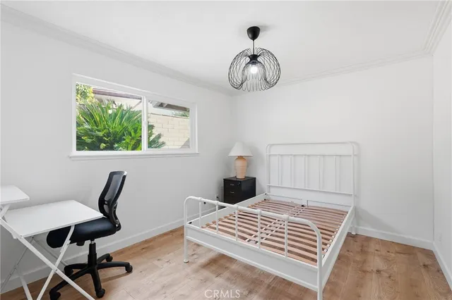 a view of a white house with a small yard and plants