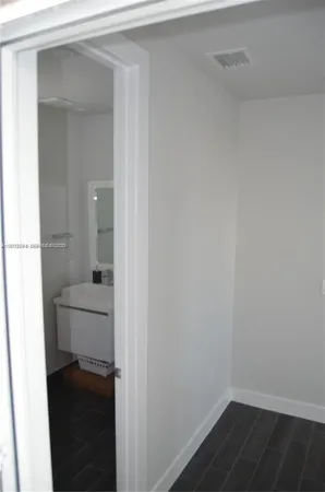 a kitchen with white cabinets and sink